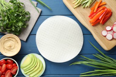 Pirinç kağıt çarşaflar ve mavi ahşap masa üzerindeki farklı malzemeler.