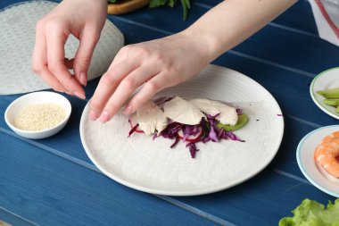Mavi ahşap masada nefis börek yapan bir kadın, yakın plan.