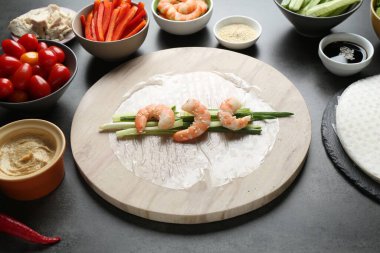 Pilav kağıtları ve koyu gri masa üzerindeki farklı malzemeler, yakın plan.