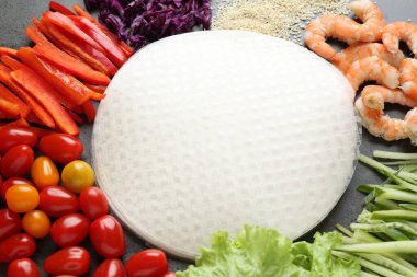 Pilav kağıtları ve koyu gri masa üzerindeki farklı malzemeler, yakın plan.