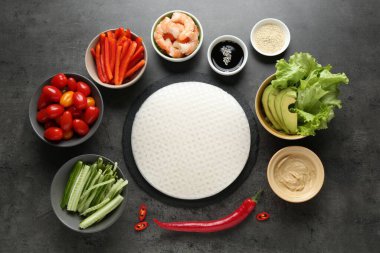 Pilav kağıtları ve farklı malzemeler koyu gri masada, düz yerde.