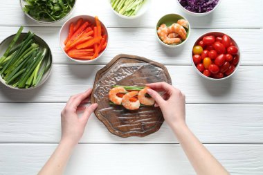 Beyaz ahşap masada nefis börek yapan bir kadın.