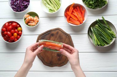 Beyaz ahşap masada nefis börek yapan bir kadın.