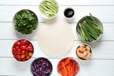 Pirinç kağıt çarşaflar ve beyaz ahşap masa üzerindeki farklı malzemeler.