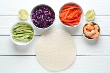 Pirinç kağıt çarşaflar ve beyaz ahşap masa üzerindeki farklı malzemeler.