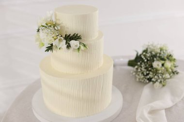 Çiçekli düğün pastası ve kapalı masa desenli lezzetli bir pasta.