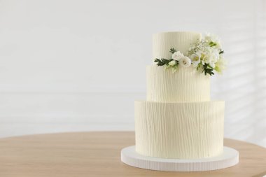 İçerideki ahşap masada çiçek desenli nefis düğün pastası, mesaj için yer.