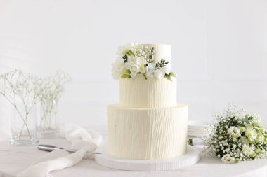 Çiçekli düğün pastası ve kapalı masa desenli lezzetli bir pasta.