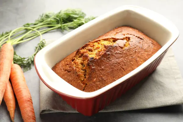 Gri desenli masada havuçlu kek ve sebzeler, yakın plan.