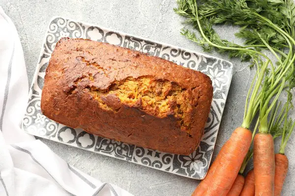 Lezzetli havuçlu kek ve sebzeler gri desenli masada, düz yatıyordu.