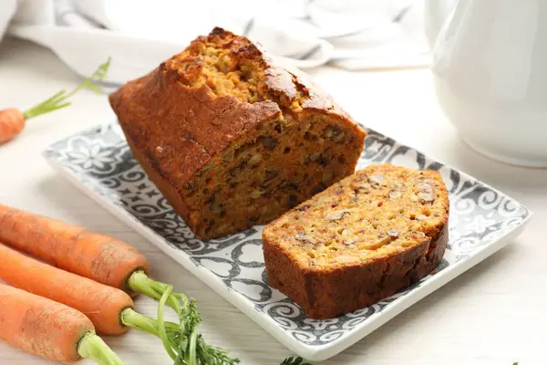 Beyaz ahşap masada fındıklı ve sebzeli ev yapımı havuçlu kek, yakın plan.