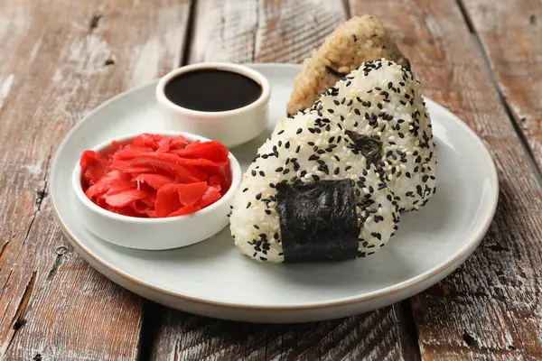 Pirinç topları (onigiri), soya sosu ve ahşap masada turşulu zencefil, yakın plan. Geleneksel Japon yemeği