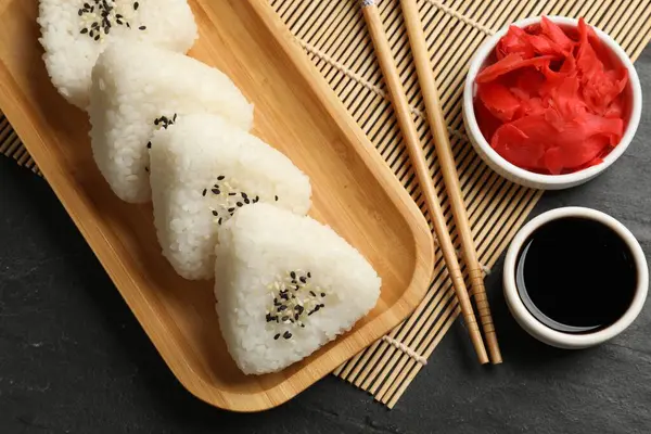 Lezzetli onigiri (Japon pirinç topları) siyah masada servis edilir.