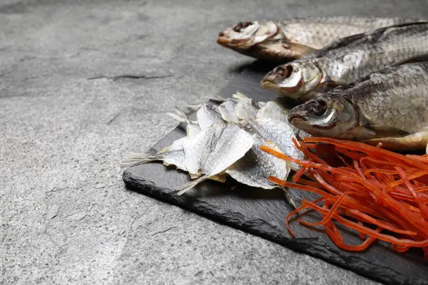 Gri masada bir sürü kurutulmuş balık aperatifi var. Yakın plan. Metin için boşluk