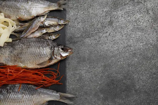 Gri masada birçok farklı kurutulmuş balık aperatifleri, üst manzara. Metin için boşluk