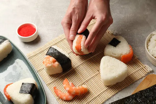 Onigiri yapan kadın (Japon pirinç topları) ışık masasında, yakın plan