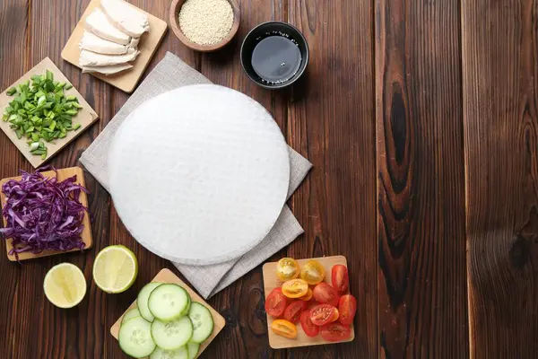 Yenebilir pirinç kağıtları ve ahşap masa üzerindeki malzemeler düz. Metin için boşluk