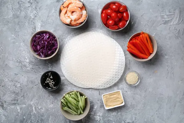 Pirinç kağıt çarşaflar ve açık gri masa üzerindeki farklı malzemeler, düz uzanmış.