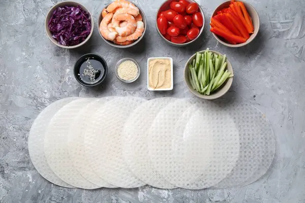 Pirinç kağıt çarşaflar ve açık gri masa üzerindeki farklı malzemeler, düz uzanmış.