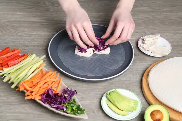 Gri ahşap masada nefis börek yapan kadın, yakın plan.