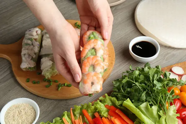 Gri ahşap masada nefis börek yapan kadın, yakın plan.