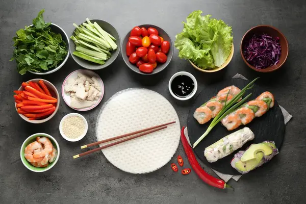 Pilav kağıtları ve farklı malzemeler koyu gri masada, düz yerde.