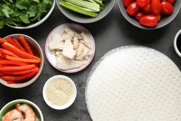 Pilav kağıtları ve farklı malzemeler koyu gri masada, düz yerde.