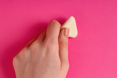 Pembe arka planda silgi kullanan kadın, yakın plan