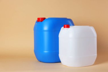 Two clean plastic canisters on beige background