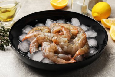 Kasede buz küpleri, baharatlar ve limonlu taze çiğ karidesler, yakın plan.