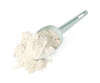 Pile of brown rice flour and scoop isolated on white, top view