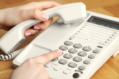 Ahşap masada telefonla arayan kadın, yakın plan.