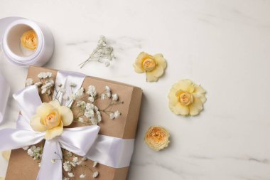 Çiçekçi. Kutu, çiçekler ve kurdele beyaz mermer masa, düz yatıyordu
