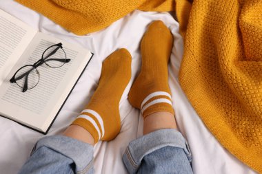 Yatakta turuncu çorap giyen bir kadın.