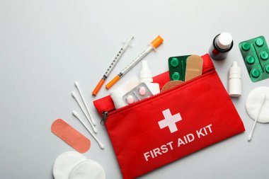 İlk yardım çantası gri arka plan üzerinde ile düz yatıyordu kompozisyon