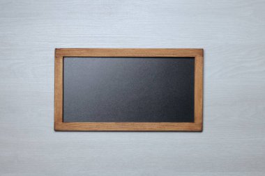 Hafif ahşap zemin üzerinde boş küçük karatahta, üst görünüm