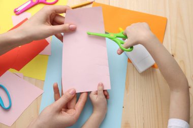 Anne ve kızı ahşap masada el yapımı bir proje yapıyorlar.