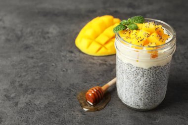 Mangolu lezzetli chia pudingi ve gri desenli masa üzerinde nane şekeri.