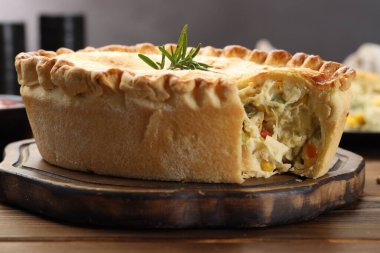 Ahşap masada biberiyeli nefis ev yapımı turta, yakın plan.