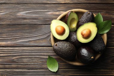 Avokado ve yaprakları ahşap masada, düz bir şekilde. Metin için boşluk