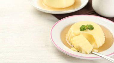 Karamel soslu lezzetli puding ve beyaz masada servis edilen nane. Metin için boşluk