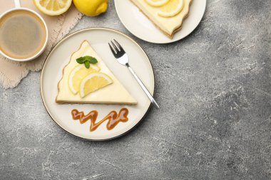 Gri desenli masada servis edilen leziz limonlu cheesecake parçaları. Metin için boşluk