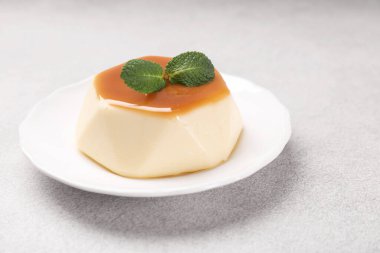 Karamel soslu lezzetli puding ve nane şekeri, yakın plan.