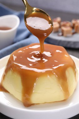 Masadaki pudingin üzerine karamel sosu dök.