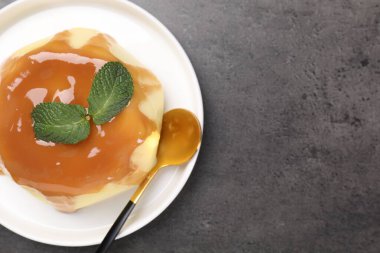 Karamel soslu lezzetli puding ve gri desenli masada servis edilen nane şekeri. Metin için boşluk