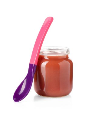Bebek maması. Cam kavanozda lezzetli püre ve beyaza izole edilmiş kaşık.