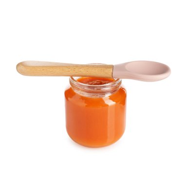 Bebek maması. Cam kavanozda lezzetli püre ve beyaza izole edilmiş kaşık.