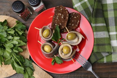 Lezzetli ringa dürümleri zeytin, maydanoz ve ekmek ahşap masada, düz uzanmış