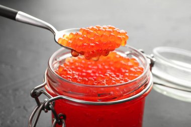 Gri masadaki cam kavanozdan kaşıkla lezzetli kırmızı havyarı alıp yakın plan çekiyoruz.