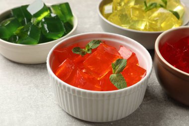 Gri masadaki kaselerde farklı jöle küpleri, yakın plan